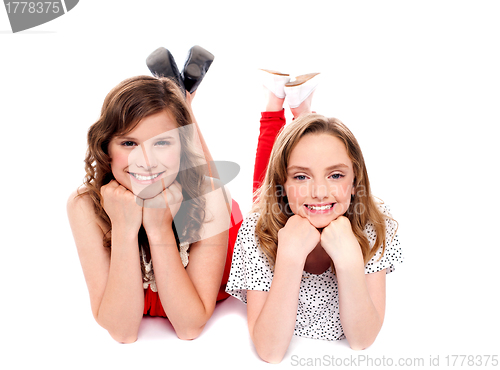 Image of Girls posing with hands on chin. Lying on floor