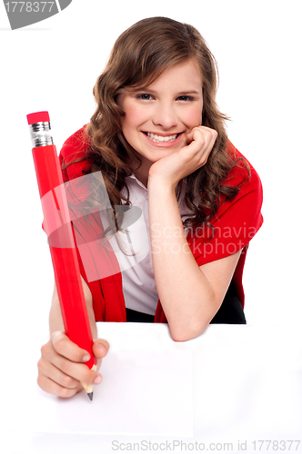 Image of Happy teenager writing with big red pencil