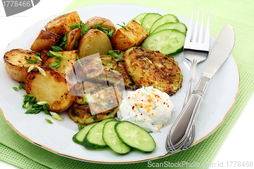 Image of Fritters zucchini, potatoes and sour cream sauce.