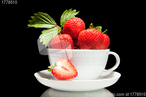 Image of red strawberry in white cup on a black background