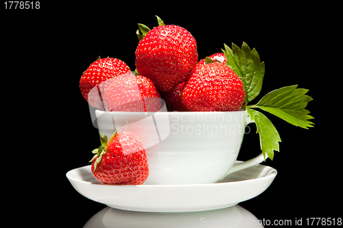 Image of red strawberry in white cup on a black background