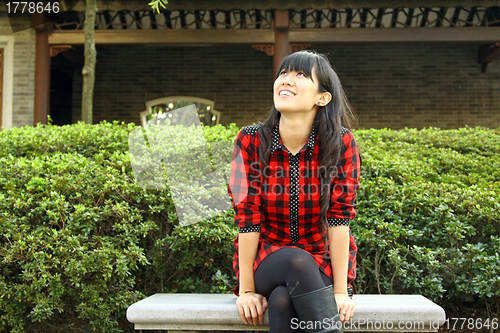 Image of Chinese girl smiling in a garden