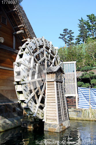 Image of Water wheel next to a house