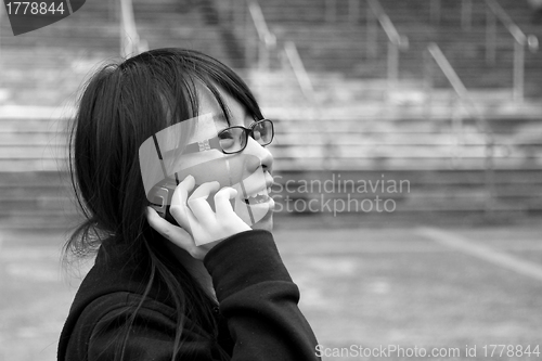 Image of Asian woman using mobile phone and talking
