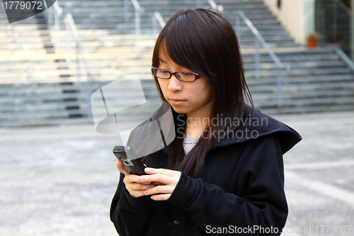 Image of Asian woman texting message by phone