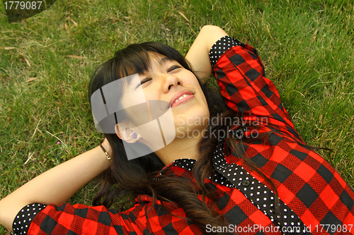 Image of Asian woman sleeping on the grass and very relax