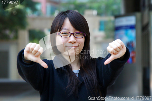 Image of Asian woman thumbs down