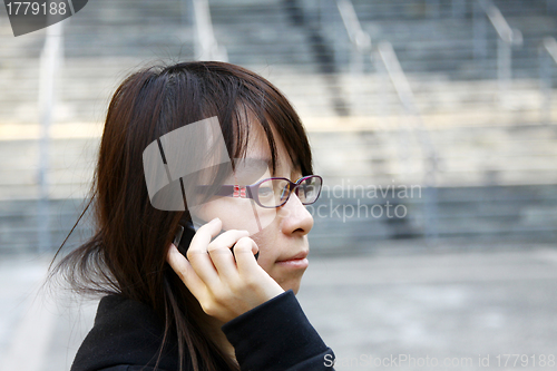 Image of Asian woman using mobile phone and talking