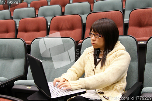 Image of Asian university student using laptop and studying