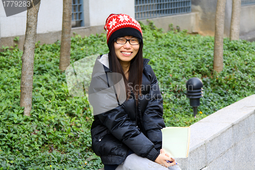 Image of Asian student smiling on campus
