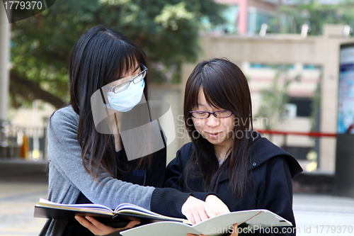 Image of Asian students studying and discussing in university