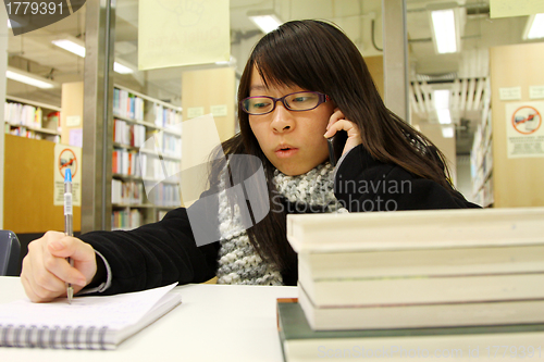 Image of Asian woman using mobile phone and talking