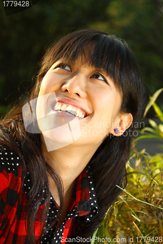 Image of Asian woman smiling under sunshine