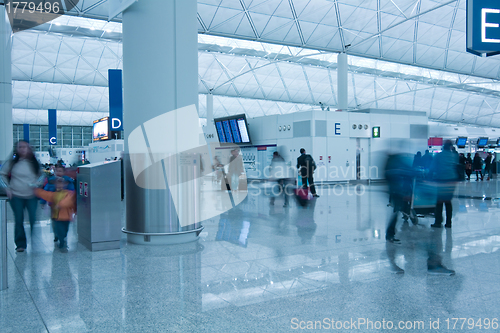 Image of Moving people in airport in blue toned