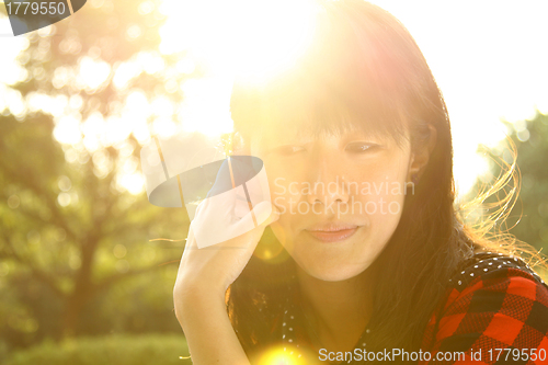 Image of Asian woman thinking under sunshine