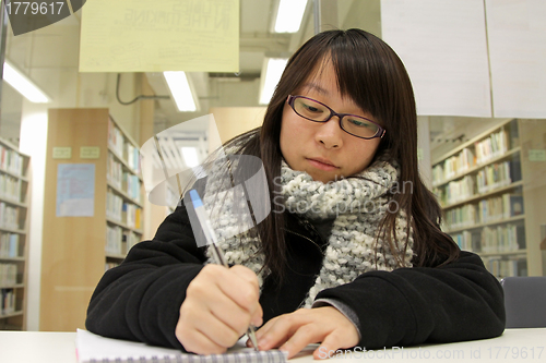 Image of Asian woman studying hard in a university