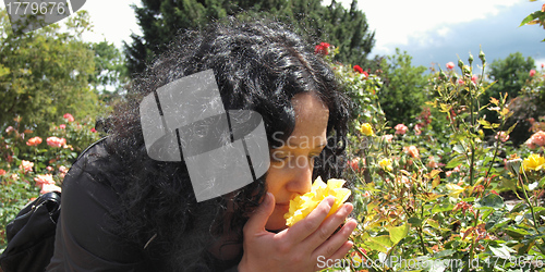 Image of Pretty brunette smelling roses