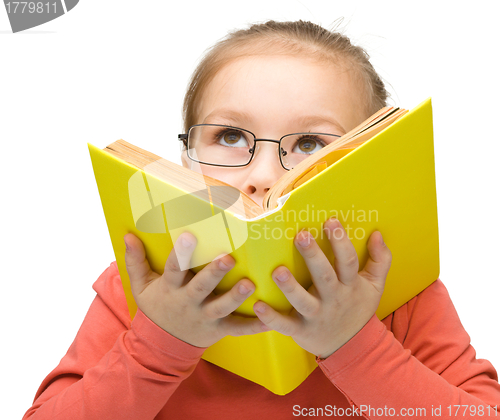 Image of Little girl is dreaming while reading book