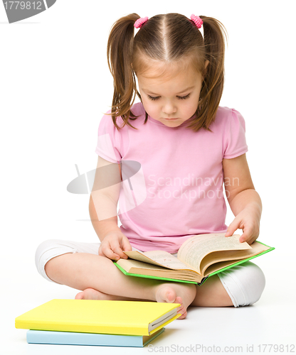 Image of Cute little girl reads a book