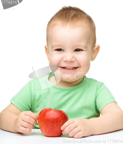 Image of Portrait of a cute cheerful little boy with apple