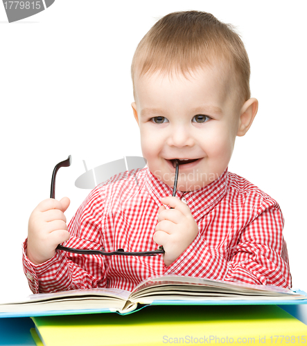 Image of Cute little child play with book