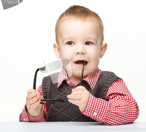 Image of Cute little child is biting glasses
