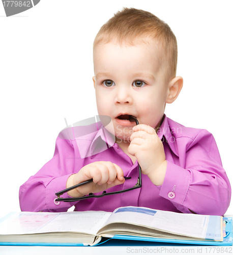 Image of Cute little child play with book