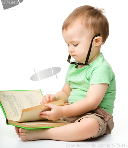 Image of Cute little boy reads a book
