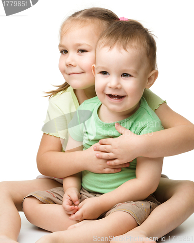 Image of Two children are having fun while sitting on floor