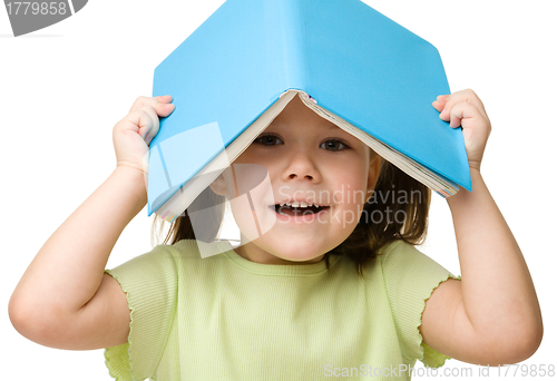 Image of Cute little girl plays with book