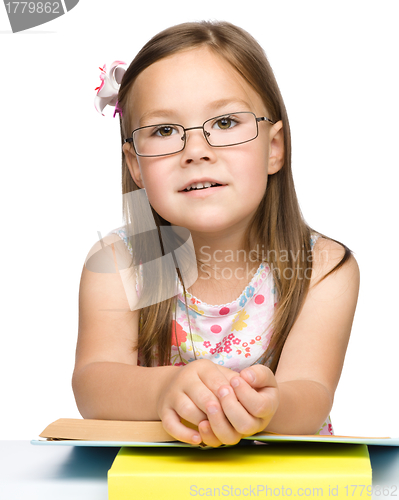 Image of Cute cheerful little girl with book