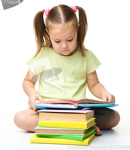 Image of Cute little girl reads a book