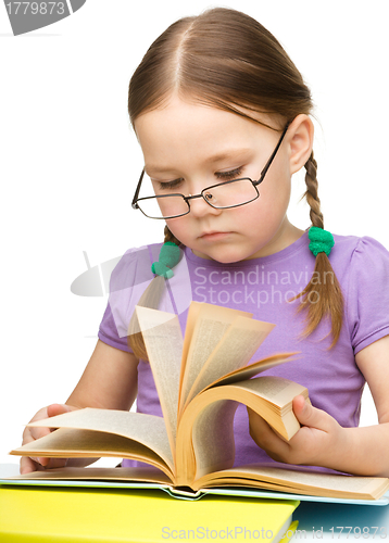 Image of Cute little girl reading book wearing glasses