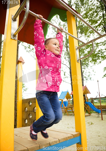 Image of Cute little girl is playing in playground