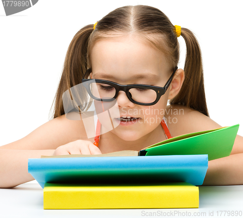 Image of Cute little girl is reading book