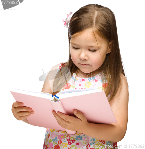 Image of Cute little girl reads a book