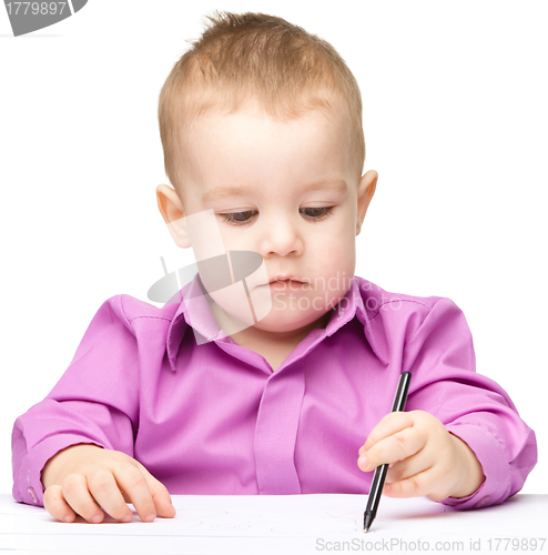 Image of Cute little boy is drawing with pen