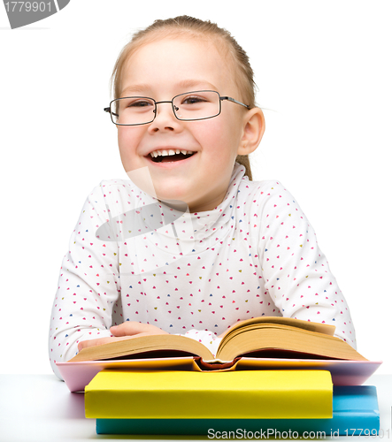 Image of Cute cheerful little girl reading book