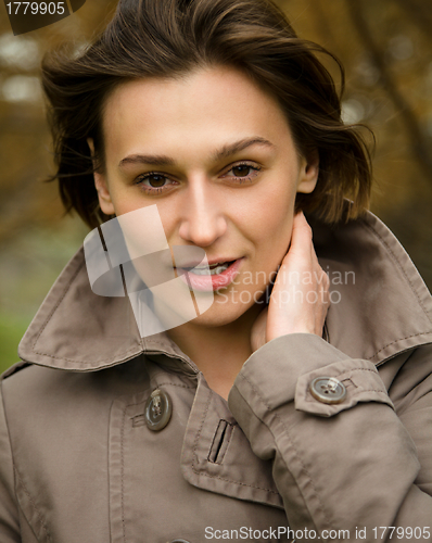 Image of Portrait of a happy beautiful woman in autumn park