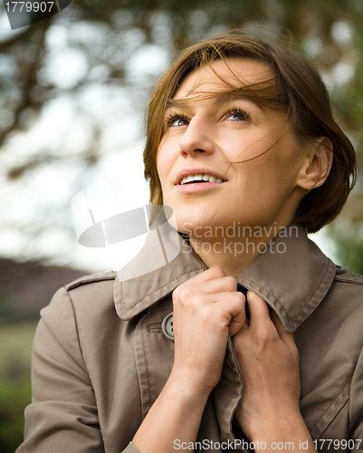 Image of Portrait of a happy beautiful woman in autumn park