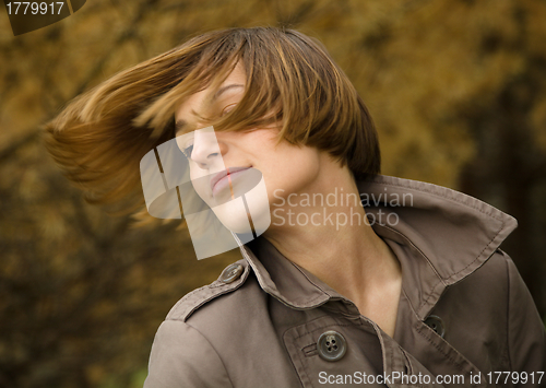 Image of Portrait of a happy beautiful woman in autumn park