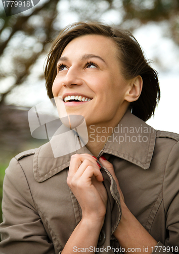 Image of Portrait of a happy beautiful woman in autumn park