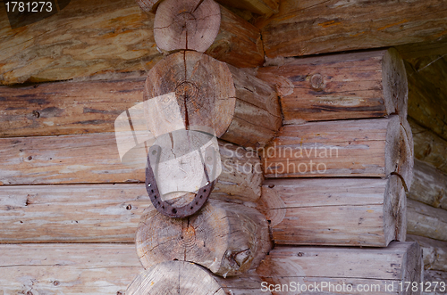 Image of Horseshoe hang on log house corner. Luch symbol 