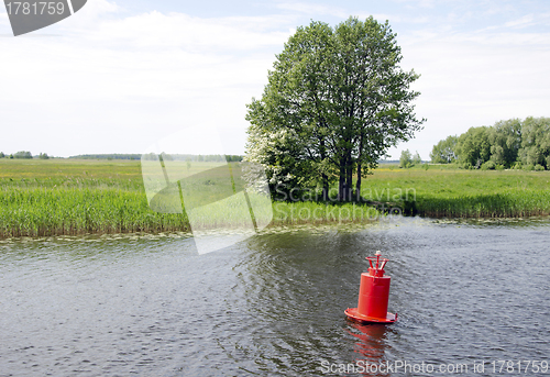 Image of Red buoy beacon in lake shore water mark for ships 