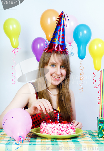 Image of Birthday. Happy attractive girl lights a candle