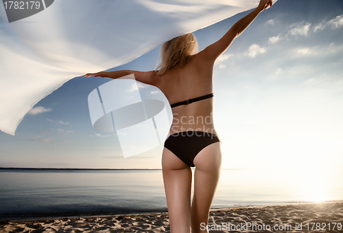 Image of young gorgeous blond at sunset on the beach
