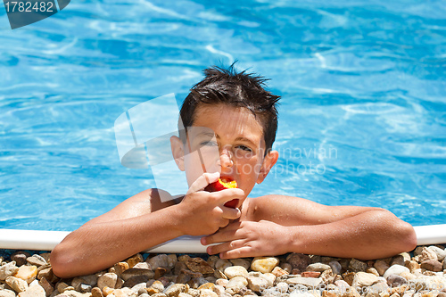 Image of Boy eating fruit in swimming pool 