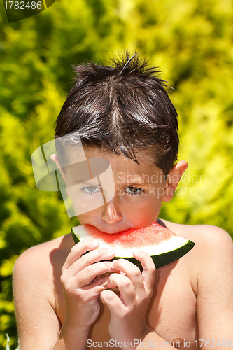 Image of wet boy with watermelon in the garden