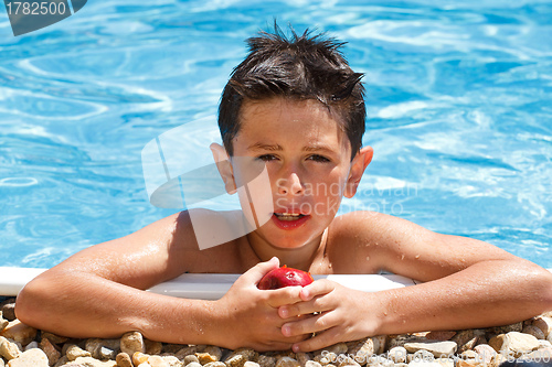 Image of Boy eating fruit in swimming pool 