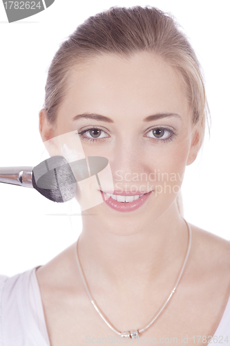 Image of young beautiful woman applying mineral powder 